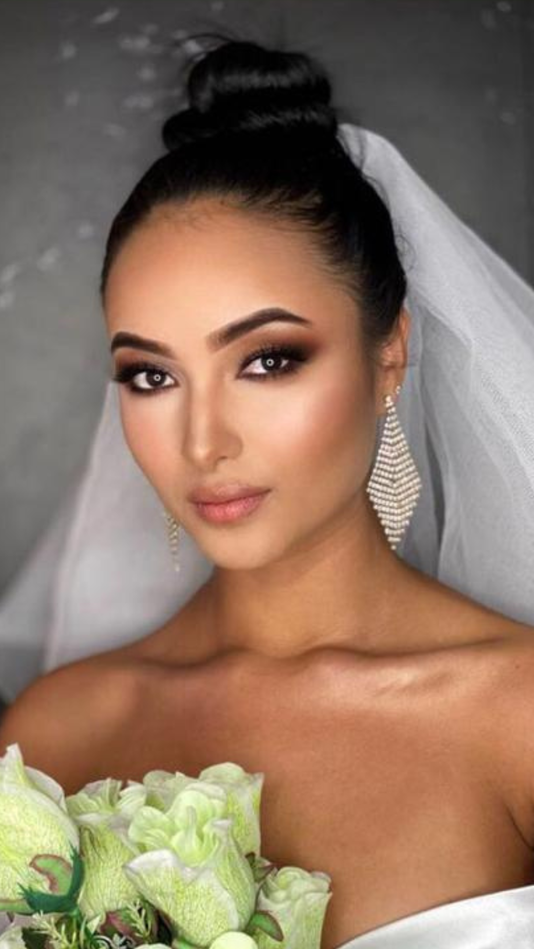 Maquillaje de novia con piel luminosa, ojos ahumados suaves y recogido pulido